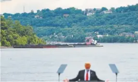  ?? John Minchillo, Associated Press file ?? A coal barge floats behind President Donald Trump during a June rally at the Rivertowne Marina in Cincinnati.