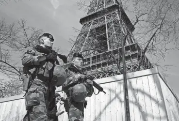  ?? BENOIT TESSIER/REUTERS ?? French soldiers patrol at the Eiffel Tower on Monday in Paris. France raised its terror alert to its highest level following Friday’s shooting in Moscow.