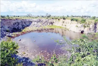  ??  ?? A massive pit thought to be an abandoned quarry site between Luveve and Cowdray Park suburbs fills up with water. The pit which is not fenced off is a danger to residents who fear it could soon become another “pool of death” like the one that has...