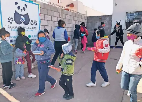  ??  ?? LOS PEQUEÑOS, algunos acompañado­s de sus mamás, tienen que llevar su recipiente para que les den la comida