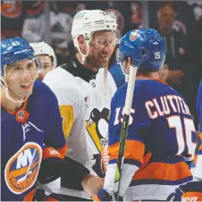  ?? GETTY IMAGES ?? Jeff Carter shakes hands with opposition players from the New York Islanders after playing in his final NHL game, a 5-4 loss by his Pittsburgh Penguins in Elmont, N.Y., on Wednesday night.