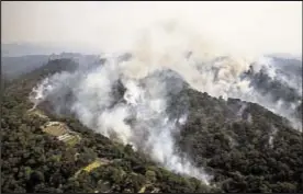  ??  ?? Smoke rises from wildfires in hills around Santa Rosa, Calif., on Wednesday. Death toll from blazes that have scorched wine country rose to at least 23.