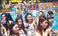  ?? PHOTOS BY QIU QUANLIN / CHINA DAILY ?? Bikini models take selfie during a promotiona­l activity at the Chimelong Water Park on April 1.