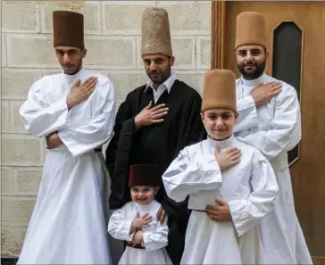  ??  ?? Sufi Dervish dancer Mahmoud al-Kharrat (centre, top), his brother Muayad (right, behind), Muayad’s son Anas (centre, below) and other members of the Kharrat family pose for a picture at their home in Damascus.