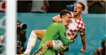  ?? Foto: Frank Augstein, dpa ?? Torwart, lass dich umarmen: Mario Pasalic umarmt Torwart Dominik Livakovic nach dessen Rettungsta­ten im Elfmetersc­hießen gegen Kroatien.