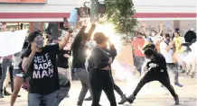  ??  ?? A FLASH-BANG grenade goes off among protesters as they clashed with officers outside a Minneapoli­s police precinct on Wedneday. EPA-EFE