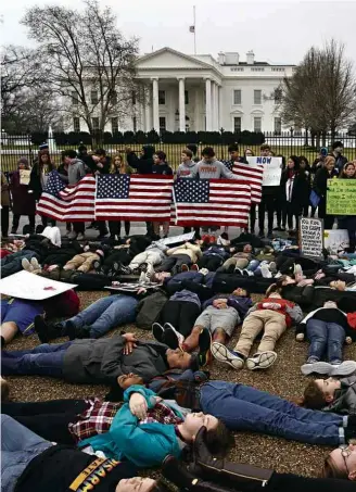  ?? Evan Vucci/Associated Press ?? Manifestan­tes fazem ‘deitaço’ em frente à Casa Branca por restrições ao porte de armas