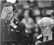  ?? Johannes Eisele / AFP via Getty Images ?? Traders work during the closing bell at the New York Stock Exchange on Monday. Investors have been jumpy since the start of the coronaviru­s crisis.