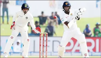  ?? (AFP) ?? Sri Lankan batsman Angelo Mathews (right), plays a shot as Indian wicketkeep­er Wriddhiman Saha looks on during the second day of the first Test match between Sri Lanka and India at Galle Internatio­nal Cricket Stadium in Galle on July 27.