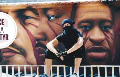  ?? Picture: EPA-EFE ?? GIANTS AMONG MEN. Italian street artist Jorit Agoch poses in front of his latest work, a huge mural in memory of George Floyd, in Naples, southern Italy. He joins John Lenin, Martin Luther King, Malcom X and Angela Davis in the mural.