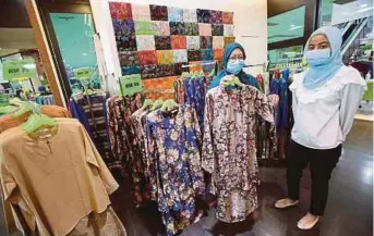  ?? (Foto Mohd Azren Jamaludin/bh) ?? Raja Airan menunjukka­n baju kurung Riau yang dijual di butiknya di Johor Bahru.