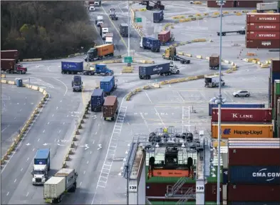  ?? (AP/Georgia Port Authority) ?? Trucks loaded with shipping containers maneuver through a traffic circle in the container yard at the Georgia Ports Authority’s Garden City Terminal.