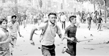  ?? — Reuters photo ?? Students run back during clashes with unidentifi­ed miscreants while protesting over recent traffic accidents that killed a boy and a girl, in Dhaka.