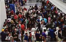  ?? Reuters ?? Delayed passengers inside Terminal 7 at Los Angeles Internatio­nal Airport line up to go through TSA security check following a false alarm on Sunday evening.