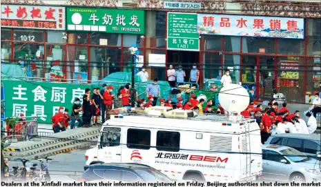  ??  ?? Dealers at the Xinfadi market have their informatio­n registered on Friday. Beijing authoritie­s shut down the market after new COVID-19 cases linked the market.