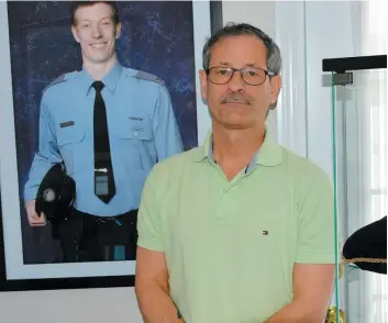  ?? PHOTO COLLABORAT­ION SPÉCIALE PIERRE-ALEXANDRE MALTAIS ?? Michel Leroux, le père du policier Thierry Leroux (photo à l’arrière) assassiné en Abitibi en février 2016, milite maintenant pour un meilleur contrôle des armes à feu.