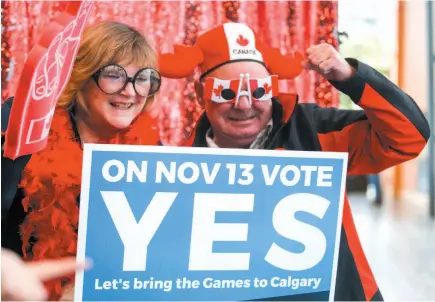  ?? CP PHOTO ?? Calgary 2026 Olympic bid supporters pose in a photo booth during a rally in Calgary on Monday.