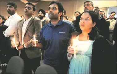  ?? Reuters ?? Alok Madasani, who was wounded in the Kansas bar shooting that killed Indian engineer Srinivas Kuchibhotl­a, sings during a candleligh­t vigil at a conference centre in Olathe. On right is Madasani's wife Reepthi Gangula. Kansas Lieutenant Governor Jeff...