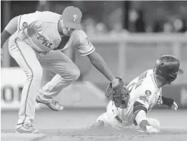  ?? MIKE EHRMANN/GETTY IMAGES ?? The Marlins Dee Gordon is tagged out by third baseman Maikel Franco as he tries to during Thursday’s game. steal