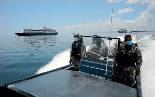  ?? AP ?? Panamanian Navy Police power past the anchored Zaandam cruise ship, carrying some guests Covid-19, after it arrived in the bay of Panama City.