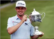  ?? CHRIS SEWARD — THE ASSOCIATED PRESS ?? J.T. Poston holds the trophy after he won the Wyndham Championsh­ip golf tournament at Sedgefield Country Club in Greensboro, N.C., on Aug. 4.