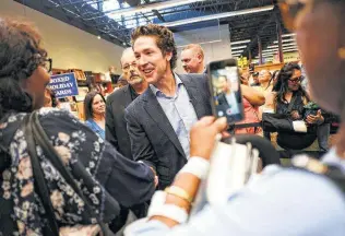  ?? Photos by Elizabeth Conley / Houston Chronicle ?? Fans and followers greet minister Joel Osteen as he arrives to sign books at a store in California.