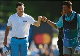  ?? NICK WASS/AP ?? Patrick Cantlay, left, fist bumps his caddie after his putt on the 18th hole during the third round of the BMW Championsh­ip on Saturday at Wilmington Country Club.