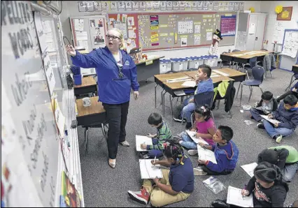  ?? DAVID BARNES PHOTOS / DAVID.BARNES@AJC.COM ?? Audrey Smith, 25, a first-grade teacher at Baldwin Elementary School near Norcross, draws a picture on the whiteboard for a class exercise earlier this month. Despite never having taught her own class before this year, Smith is learning how to lead...