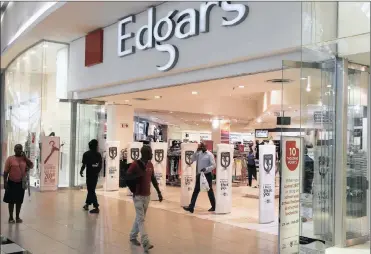  ?? PHOTO: REUTERS ?? Shoppers walk past an Edgars store at a shopping centre in Soweto. Edcon has launched a turnaround strategy which looks as though it might be bearing fruit.