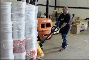  ?? Spencer Lahr / Rome News-Tribune ?? Daniel Banks, a volunteer with the Floyd County Sheriff’s Office Posse, pushes a pallet loaded with disaster relief cleaning kits.