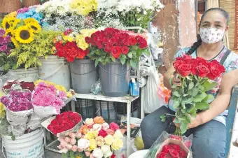  ??  ?? María Alvear, más conocida como “chilena”, prepara las rosas rojas para la venta. Ella está en su puesto ubicado en el Mercado 4, sobre la calle Pettirossi.