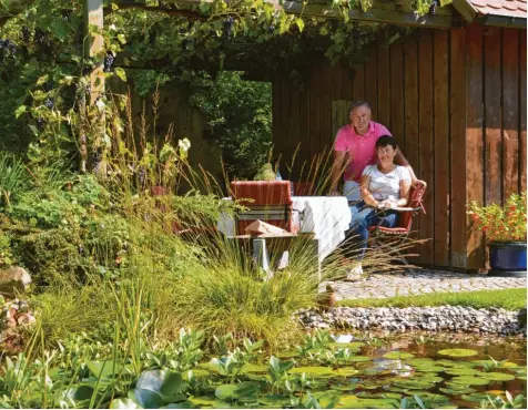  ?? Fotos: Cecilia Weber ?? Erwin und Siglinde Ballis genießen die Ruhe im hinteren Garten. Beide sitzen gerne unter dem geschützte­n Bereich und beobachten ihre Goldfische und die Frösche, die in ihren Teich zum Baden kommen.