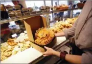  ?? GERALD HERBERT — THE ASSOCIATED PRESS ?? A King cake is boxed for sale in La Boulangeri­e bakery in New Orleans. People in this town take tradition seriously and few traditions are as important as King Cake.