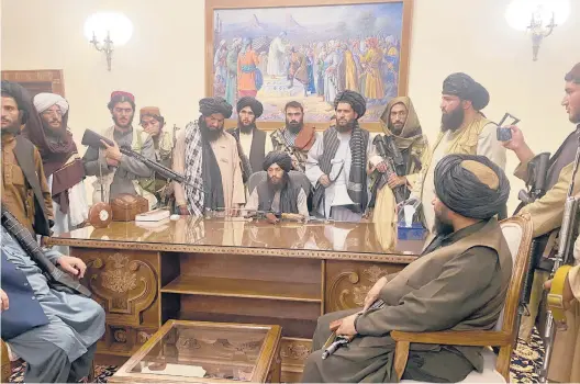  ?? ZABI KARIMI/AP ?? Taliban fighters take control of Kabul’s abandoned presidenti­al palace in Afghanista­n on Sunday after President Ashraf Ghani fled the country.