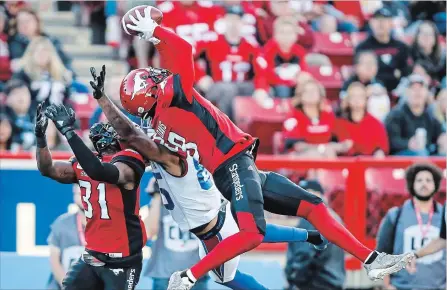  ?? JEFF MCINTOSH THE CANADIAN PRESS ?? The Stampeders’ Emanuel Davis intercepts a pass intended for the Alouettes’ B.J. Cunningham during second-half action in Calgary on Saturday.