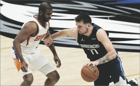  ?? TONY GUTIERREZ/AP ?? DALLAS MAVERICKS GUARD LUKA DONCIC (77) drives with the ball against Phoenix Suns guard Chris Paul (left) during the second half of Game 6 of a second-round playoff series on Thursday in Dallas.