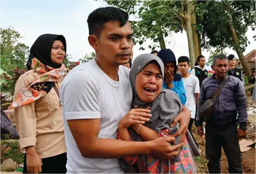  ?? ?? Relatives cry during the funeral of 48-year-old victim Husein, who was killed while building a house, at a village near Cianjur, on Tuesday following a 5.6-magnitude earthquake. — afp