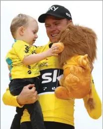  ?? BRYN LENNON, GETTY IMAGES ?? Chris Froome of Britain and Team Sky holds his son Kellan on the podium after winning the Tour de France for the fourth time Sunday.