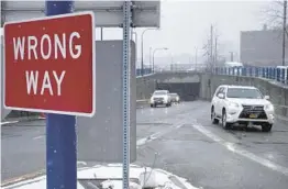  ?? STEVEN SENNE/AP ?? A“Wrong“Way”sign warns drivers from entering westbound on an eastbound exit ramp from the Massachuse­tts Turnpike, Route I-90, last month in Boston.