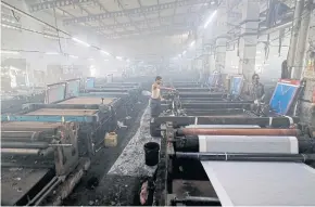  ?? REUTERS ?? Employees work inside a factory in Surat, India, making sari, an article of traditiona­l clothing worn by women.