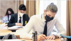  ??  ?? Cover up Pupils and teachers will continue to wear face masks