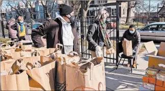  ?? ZBIGNIEW BZDAK/CHICAGO TRIBUNE ?? Fabiola Rodriguez, right, receives groceries at the food pantry at Harmony Community Church in Chicago’s Lawndale neighborho­odWednesda­y. The Greater Chicago Food Depository supplies the food pantry.