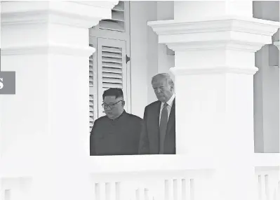  ?? ANTHONY WALLACE /AFP/GETTY IMAGES ?? North Korea’s leader Kim Jong Un walks with President Donald Trump after a signing ceremony in Singapore on June 12.