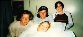  ??  ?? Patrick in Burwood hospital after the accident. With him from left is Christian Ross and Tom McKenzie who had been at the swimming hole when the accident occurred, and another friend Amanda Eldridge (nee Hewitt).