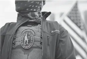  ?? STEFANI REYNOLDS/ BLOOMBERG VIA GETTY IMAGES ?? A demonstrat­or wears an Oath Keepers badge on a protective vest at a protest outside the Supreme Court on Jan. 5.