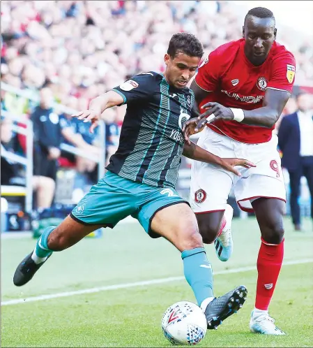  ??  ?? INCOMING: Swansea’s Kyle Naughton crosses as Bristol City’s Famara Diedhiou adds pressure