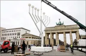  ?? ?? Rabbis oversee the placing of a menorah at the Brandenbur­g Gate in Berlin ahead of Hanukkah