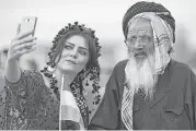  ?? Safin Hamed / AFP / Getty Images ?? In Bahrka, Iraq, a Kurdish woman takes a selfie with a man as they take part in a rally urging people to vote in the upcoming independen­ce referendum.