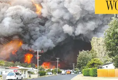  ?? KELLY-ANN OOSTERBEEK / AFP VIA GETTY IMAGES ?? Flames from an out-of-control bushfire advance toward a nearby residentia­l area in Harrington, some 335 km northeast of Sydney on Friday. Australian firefighte­rs warned that they were in “uncharted territory”
as they struggled to contain dozens of raging bushfires across the east of the country.