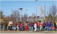  ?? STAFF PHOTO BY OLIVIA ROSS ?? Pro-union supporters walk away from the Volkswagen Chattanoog­a plant with their signs in December.